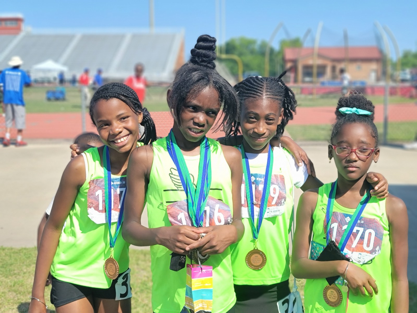 Youth track teammates wearing their medals