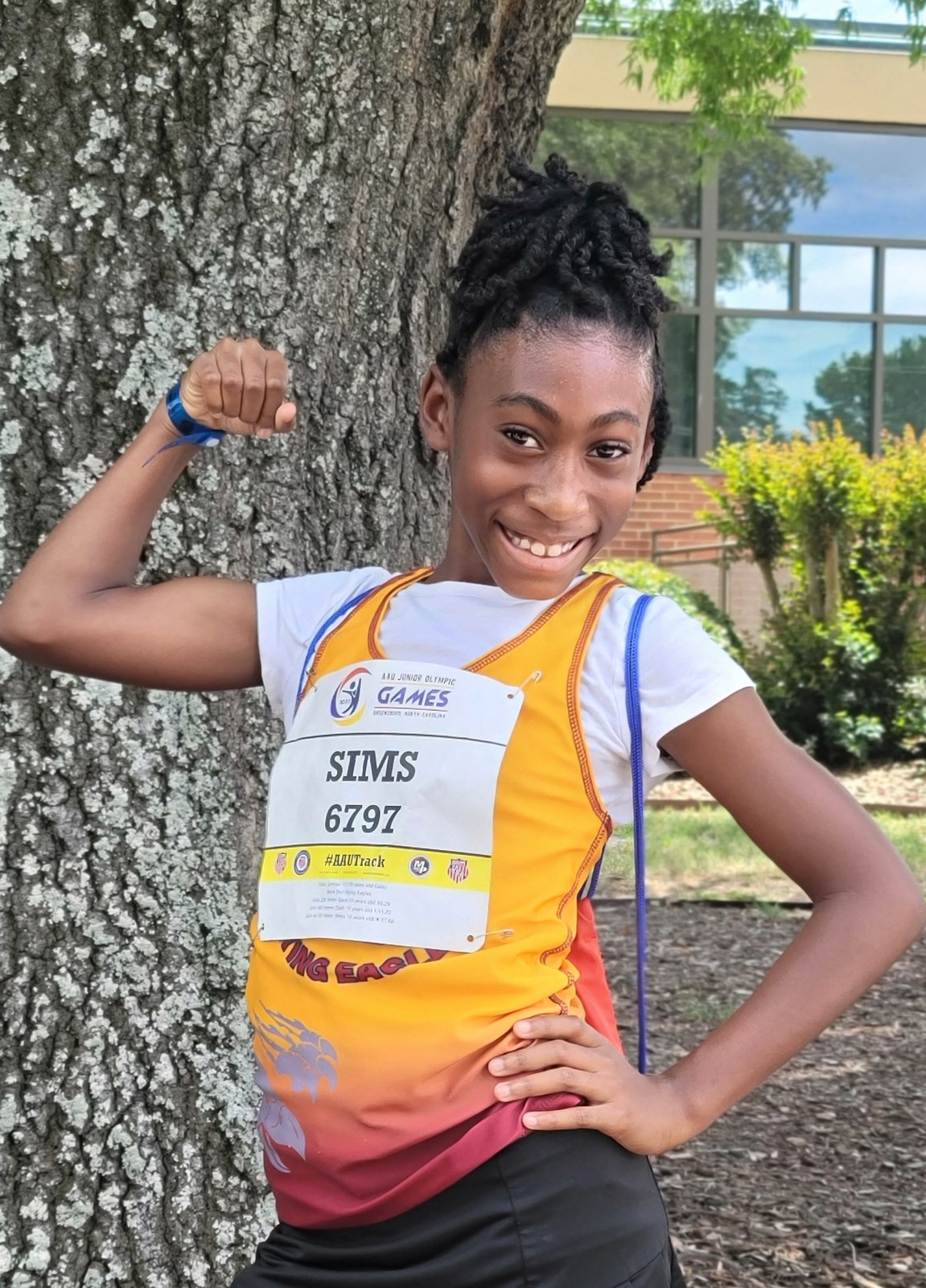 Samiya in her track uniform, posing with a medal